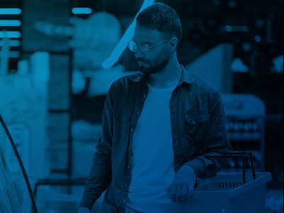 male shopper carrying a basket  shopping in refrigerated section of retail supermarket