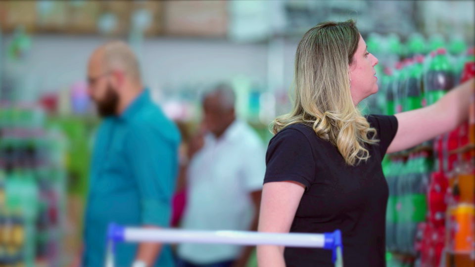 multi-ethnic clientele pushing shopping carts and slecting items from shelves in warehouse retail store