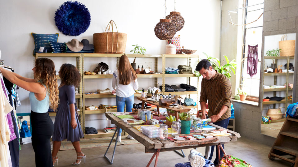 busy brightly lit boutique retail store with several customers and associates working and browsing in the store