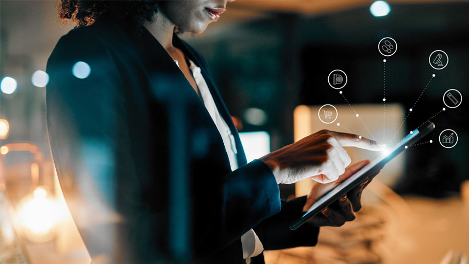 conceptual image of woman touching a tablet device with sensormatic iq icons overlaid