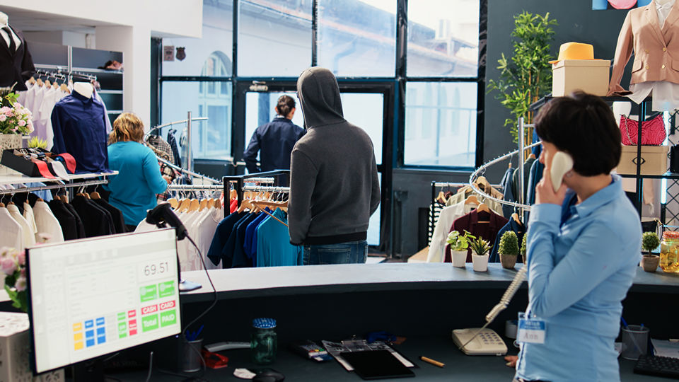 man in hoodie possible shoplifter in retail apparel store reported by store sales associate